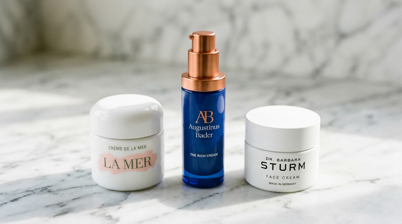 Luxury moisturiser comparison — La Mer, Augustinus Bader, and Dr. Barbara Sturm on marble surface
