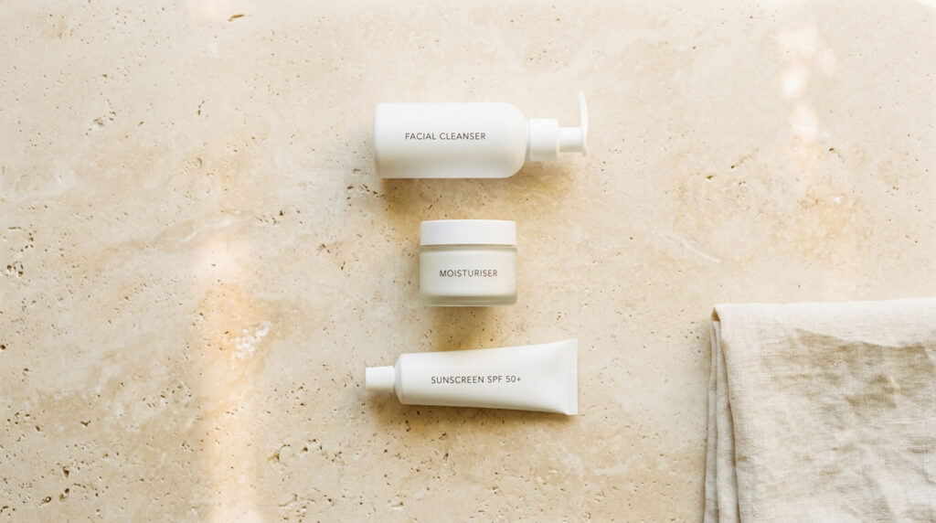 Simple skin barrier repair routine with three products on warm stone surface