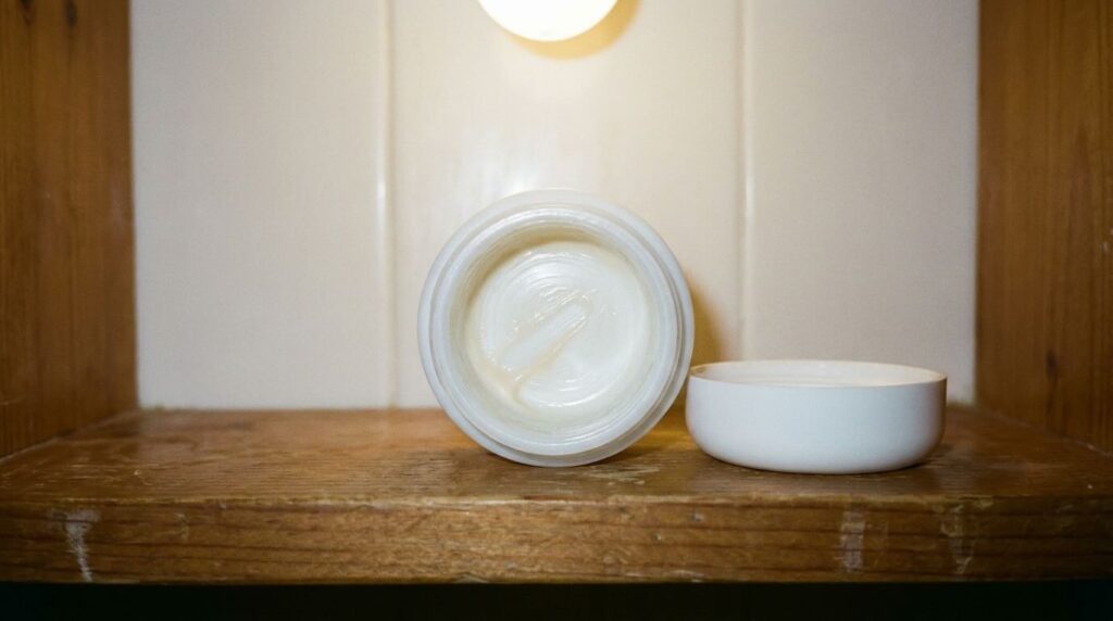 Nearly empty La Mer jar scraped clean on bathroom shelf in honest flat light