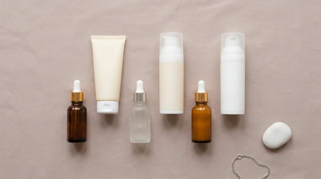 Six melasma-friendly skincare products grouped on soft taupe linen in diffused morning light